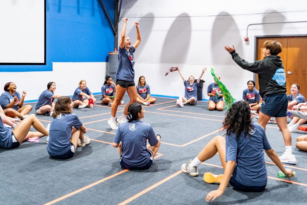 Teenage girl jumps up as she celebrates during a team activity at Group Dynamix