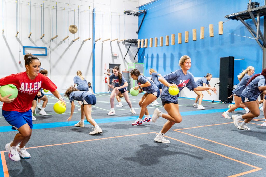 Girls from a volleyball team playing dodgeball during a team event at Group Dynamix