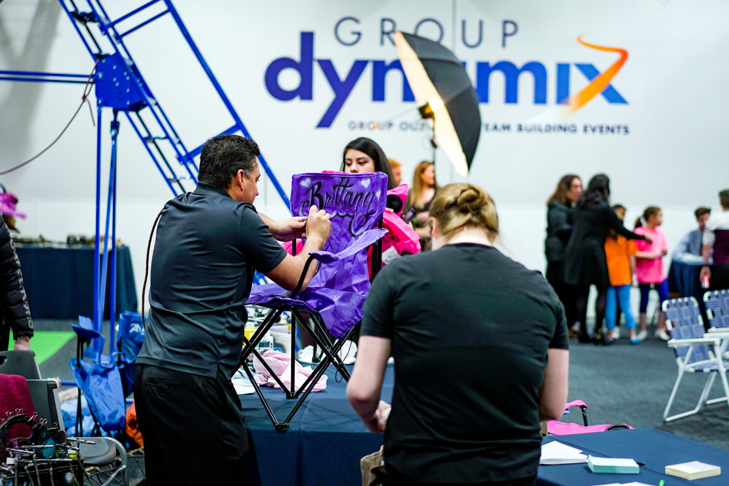 Artist painting a chair during a Bar Mitzvah at Group Dynamix