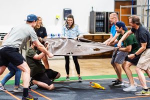 Group of teachers holding a tarp during a team bonding activity at Group Dynamix