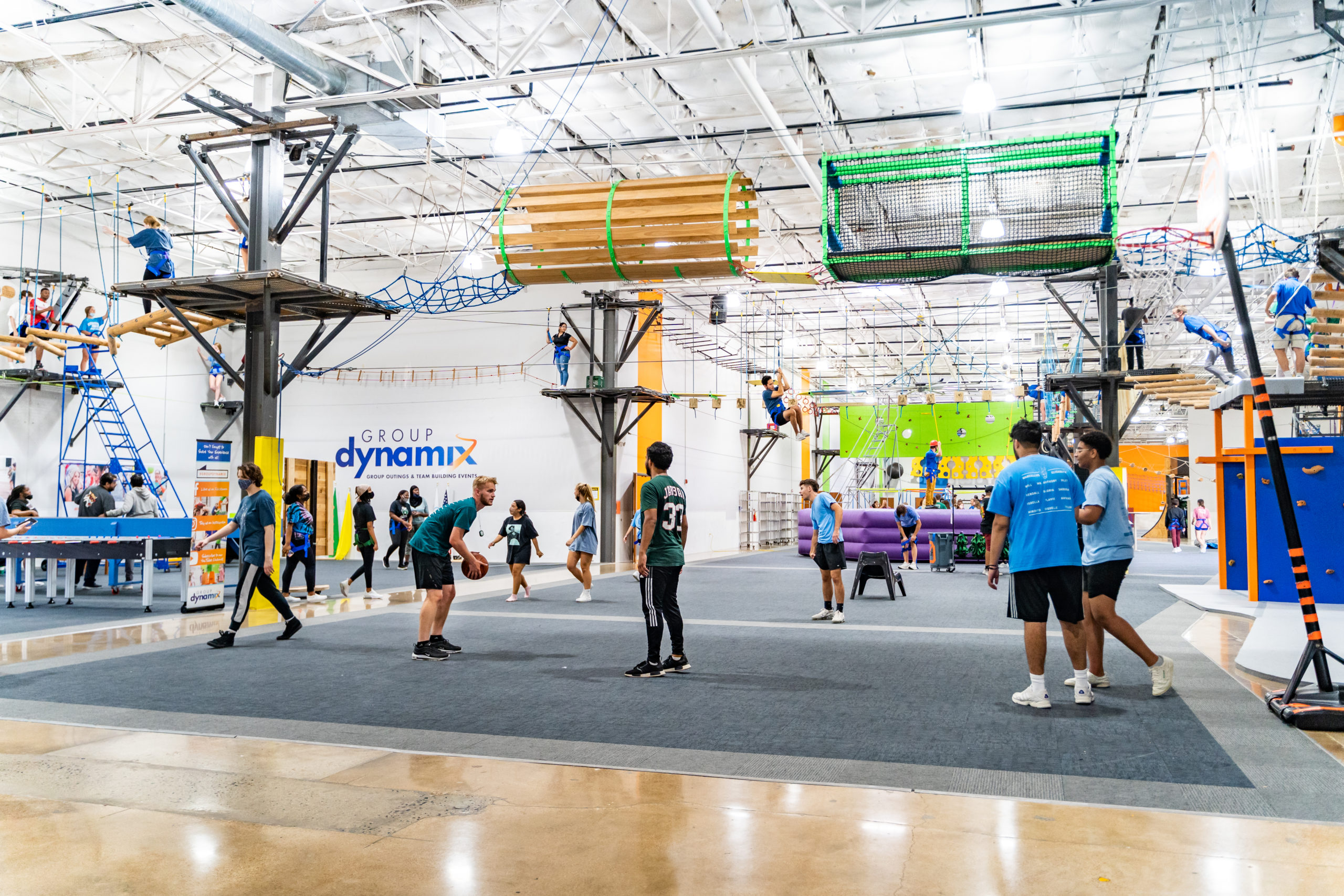 Group of teenage students playing basketball and zip lining at Group Dynamix during a team building event