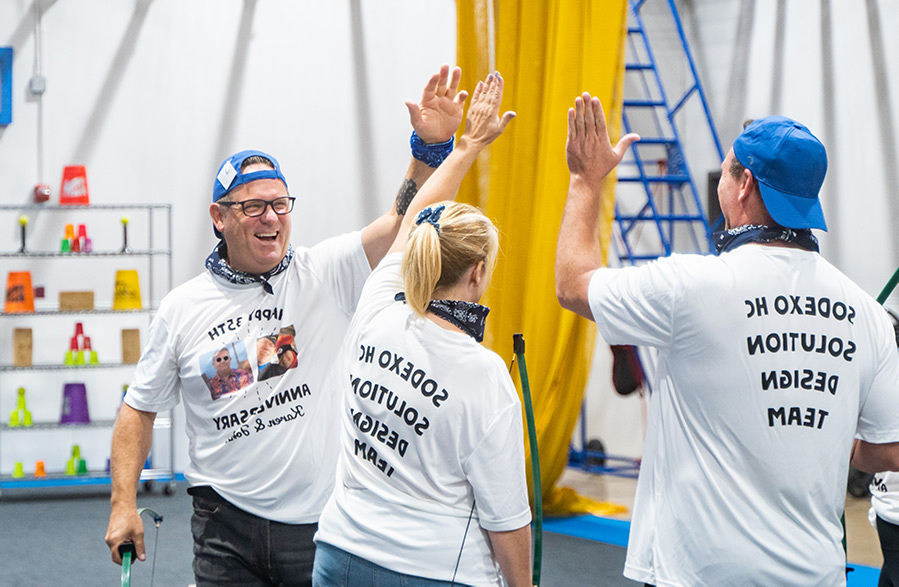 Group of teenagers in a huddle during a team building activity at Group Dynamix