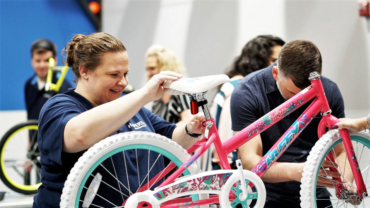 lady building a bike with her colleague during a holiday and charity event