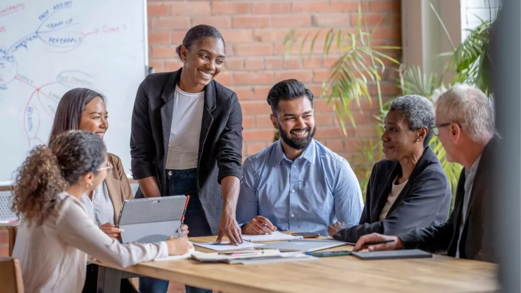 Diverse team collaborating during a meeting and sharing fun staff training ideas to boost engagement and teamwork in 2025.