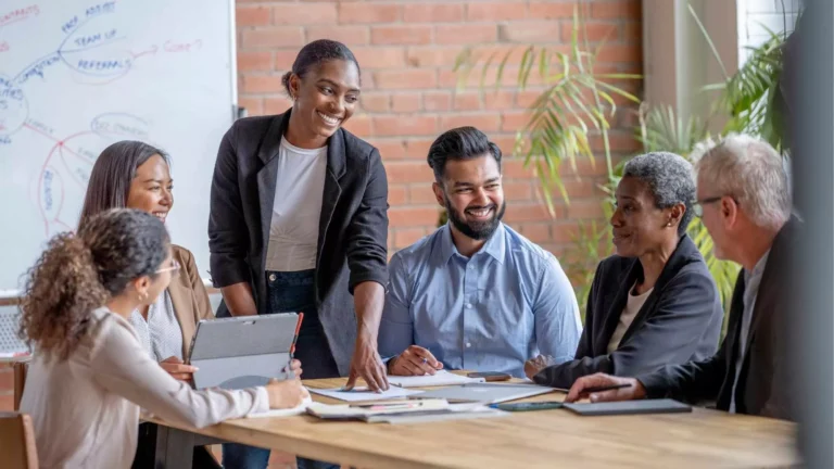 Diverse team collaborating during a meeting and sharing fun staff training ideas to boost engagement and teamwork in 2025.