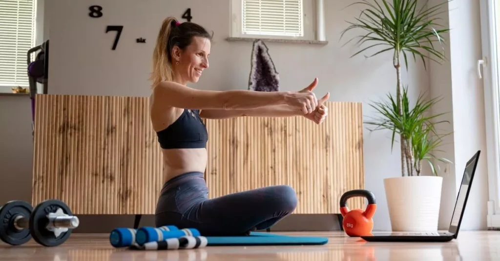 Woman doing online fitness session at home demonstrating wellness and mindfulness engagement activities for remote teams to support mental health.