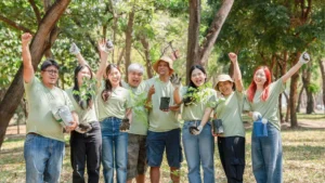 Team volunteers celebrating after planting trees together, representing spring team building ideas that promote collaboration and purpose.