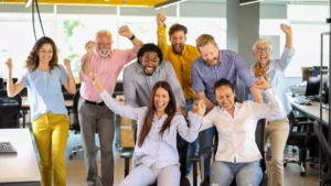 Employees celebrating together in an office after a shared success, highlighting affordable team building activities that boost morale and teamwork.