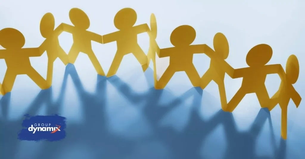 Illustrated paper figures holding hands to represent connection and alignment through affordable team building activities tailored to team challenges.