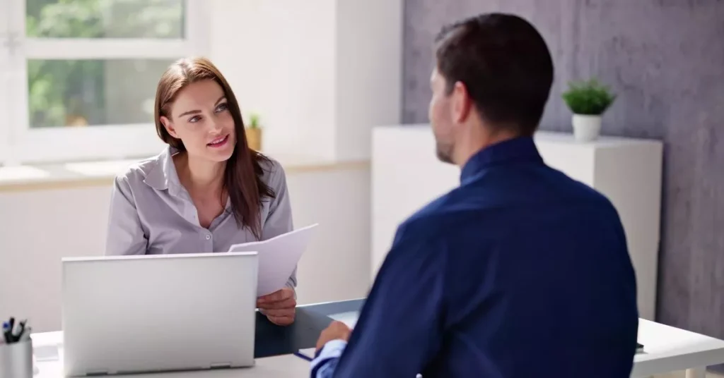 Manager and employee in a one-on-one meeting discussing goals and expectations to build trust in teams through accountability.