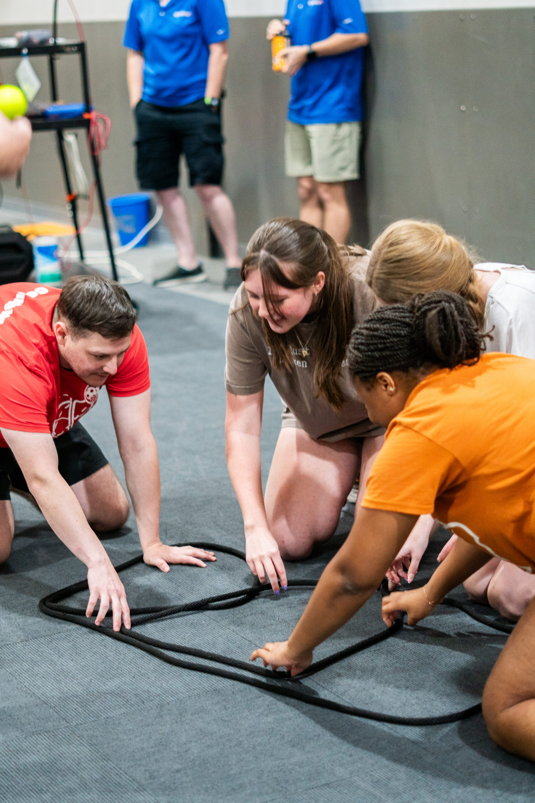 A small group collaborating during a hands-on rope challenge