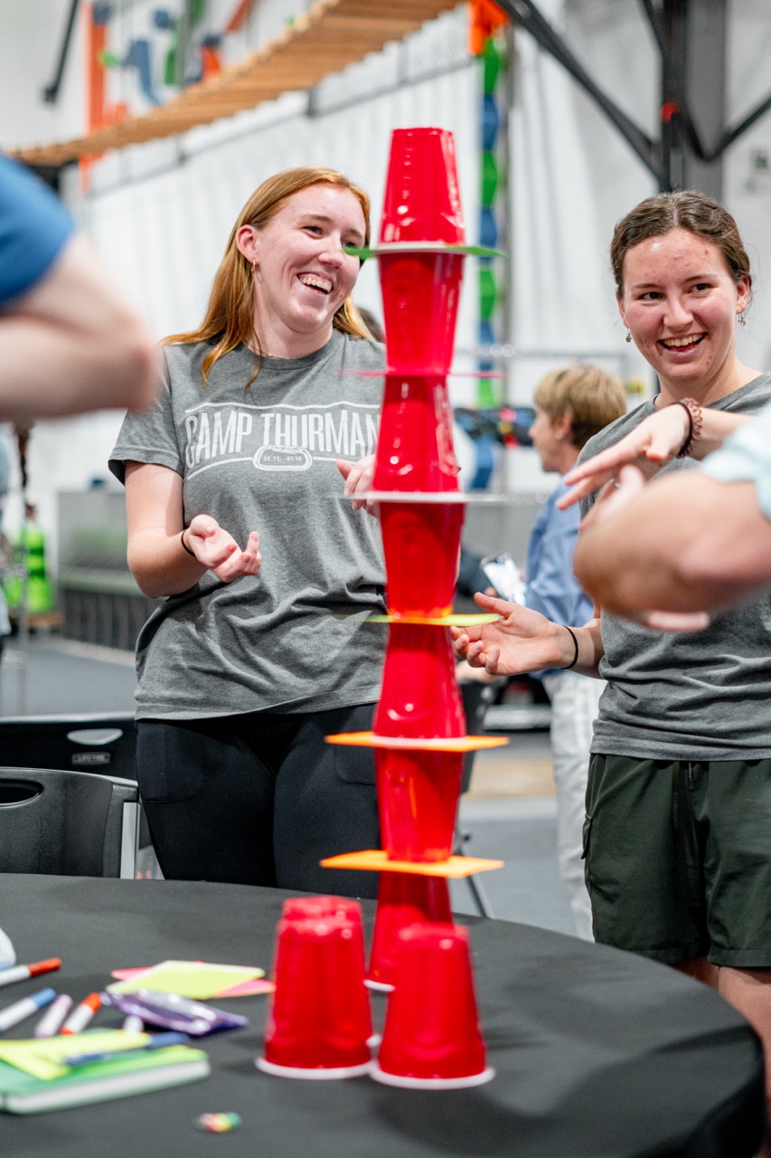 Participants smiling during a collaborative cup stacking activity